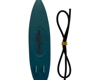 Könnte beinhalten: Eine tealblaue, surfboardförmige Garn-Schale mit dem aufgedruckten Text "Hang Two". Die Schale wird mit einer schwarzen elastischen Schnur zum Aufhängen geliefert.