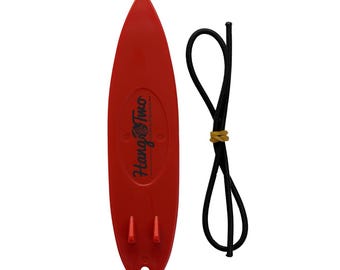 Könnte beinhalten: Roter Schlüsselanhänger in Form eines Surfbretts mit dem Text "Hang Two" und einer schwarzen Schnur.