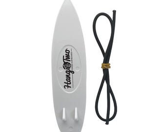 Könnte beinhalten: Weißes Finger-Surfbrett aus Kunststoff mit dem Aufdruck "Hang Two - Finger Surfboards". Das Surfbrett wird mit einer schwarzen Gummikordel geliefert.