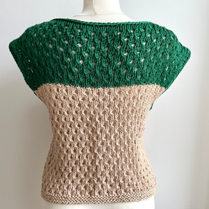 Puede incluir: Una blusa de dos tonos con tejido abierto. La secci&oacute;n superior es de color verde liso, mientras que la secci&oacute;n inferior es de color beige. La blusa tiene cuello redondo y mangas cortas. El dobladillo inferior es de punto liso.