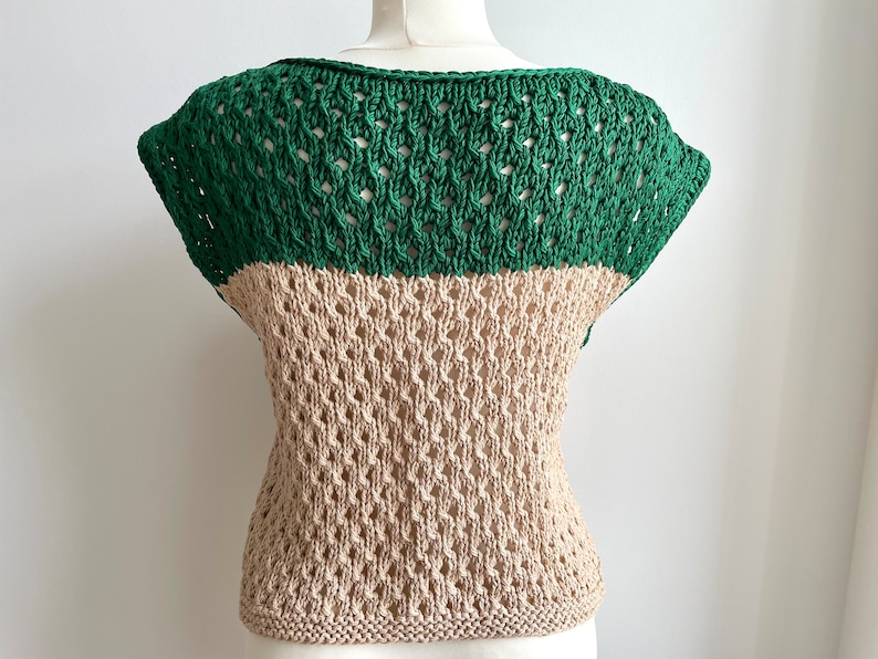 Puede incluir: Una blusa de dos tonos con tejido abierto. La secci&oacute;n superior es de color verde liso, mientras que la secci&oacute;n inferior es de color beige. La blusa tiene cuello redondo y mangas cortas. El dobladillo inferior es de punto liso.