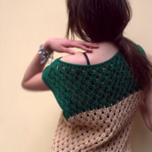 Puede incluir: Top de ganchillo de dos tonos en verde y beige. El top presenta un dise&ntilde;o de tejido abierto y un escote redondo. La secci&oacute;n verde cubre los hombros y la parte superior de la espalda, mientras que la secci&oacute;n beige cubre la parte inferior de la espalda y el torso. El top se lleva con vaqueros.