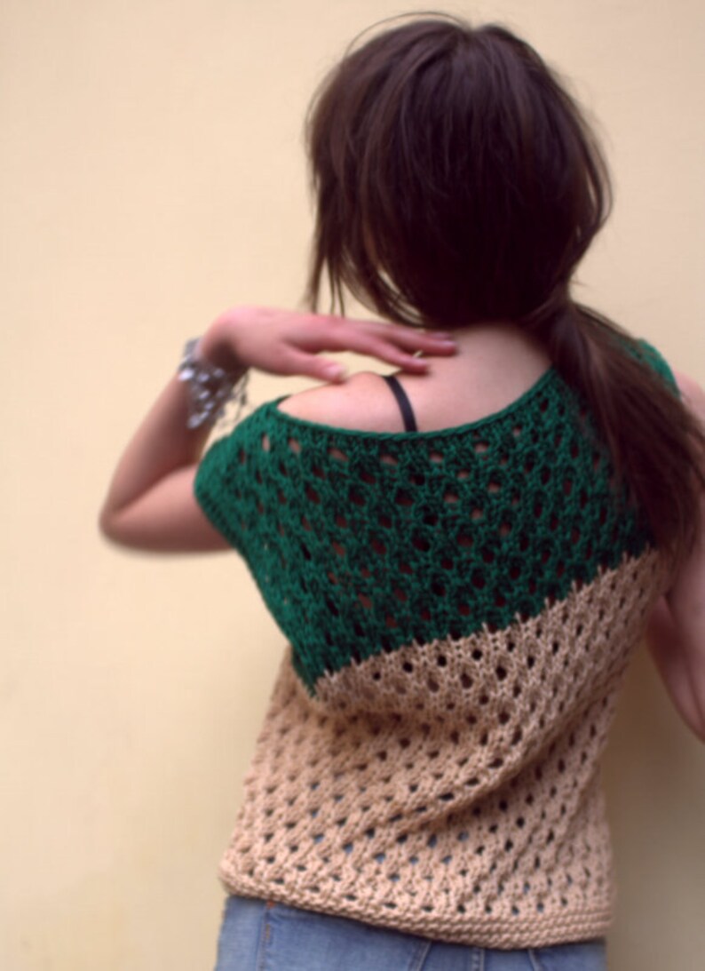 Puede incluir: Top de ganchillo de dos tonos en verde y beige. El top presenta un dise&ntilde;o de tejido abierto y un escote redondo. La secci&oacute;n verde cubre los hombros y la parte superior de la espalda, mientras que la secci&oacute;n beige cubre la parte inferior de la espalda y el torso. El top se lleva con vaqueros.