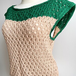 Puede incluir: Top sin mangas de dos tonos con dise&ntilde;o calado. El cuello y los tirantes son verdes, mientras que el cuerpo es beige. La parte superior se muestra en un maniqu&iacute; blanco. El tejido abierto y el bloqueo de color crean un look elegante.