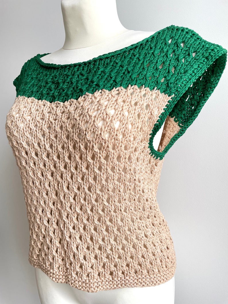 Puede incluir: Top sin mangas de dos tonos con dise&ntilde;o calado. El cuello y los tirantes son verdes, mientras que el cuerpo es beige. La parte superior se muestra en un maniqu&iacute; blanco. El tejido abierto y el bloqueo de color crean un look elegante.