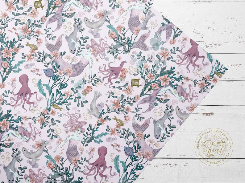A wrapping paper featuring mermaids, octopuses, and seals in a whimsical underwater scene. The pattern is set against a light pink background with delicate floral accents and bubbles.