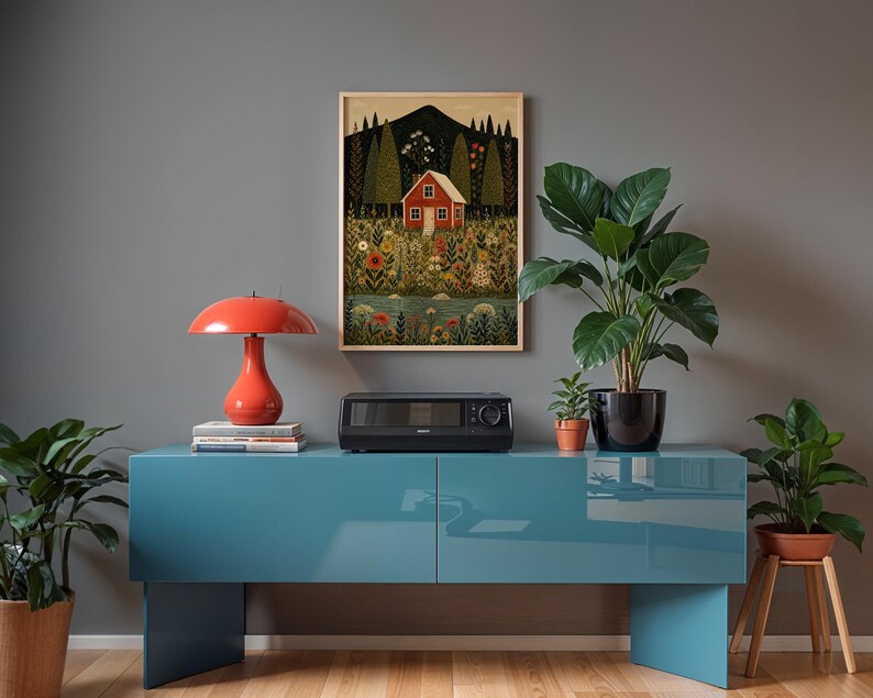May include: A teal blue cabinet with a red lamp, a black appliance, and a framed picture of a red house in a field. Potted plants are on the cabinet and on a wooden stool. The background is a gray wall.