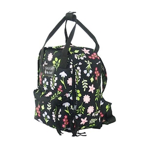 May include: Black floral backpack featuring pink, white, and green flowers. It has a top handle and adjustable straps. The text "SARRA by Sof" is printed on the front of the bag.