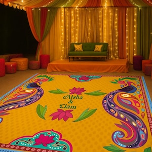 May include: A square dance floor wrap featuring a vibrant yellow background with colourful peacock illustrations, pink lotus flowers, and the text "Aisha & Liam" in the centre. The design includes intricate borders and decorative patterns.