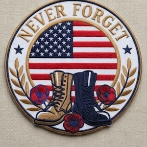 May include: Embroidered patch with the words "NEVER FORGET" and an American flag design. Features two pairs of boots, red poppies, and a gold laurel wreath. The patch is circular with a white border.