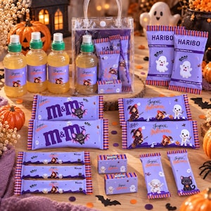 Peut inclure: Une collection de friandises sur le thème d'Halloween comprenant trois bouteilles en plastique transparent avec des bouchons verts, deux sachets Haribo, deux paquets de M&M's, deux barres KitKat, trois barres Kinder, deux boîtes Smarties et deux barres supplémentaires, le tout dans des emballages violets avec des graphismes festifs.
