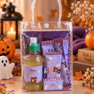 Peut inclure: Un sac cadeau en plastique transparent avec fermeture à pression et poignée contenant une bouteille de liquide jaune avec un bouchon vert, deux barres chocolatées violettes et une petite boîte rectangulaire avec Joyeux Halloween.