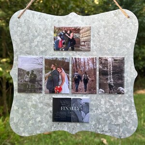 May include: A galvanised metal photo display with a decorative edge, strung with twine. It holds six rectangular photos of various sizes, including wedding and outdoor scenes. The bottom photo has the text "FINALLY" and "love".