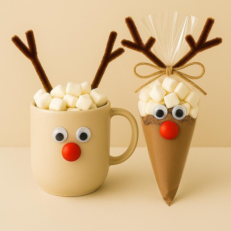 May include: A beige mug and a cone-shaped bag, both decorated as reindeer. The mug is filled with marshmallows, has googly eyes, a red nose, and brown pipe cleaner antlers. The bag contains cocoa mix and has similar decorations.