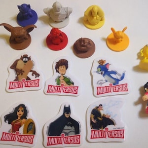 May include: A collection of 15 MultiVersus character figurines. The figurines are made of plastic and feature various characters from the game, including Batman, Harley Quinn, Bugs Bunny, and Tom and Jerry. The figurines are all in different poses and have a variety of colors.