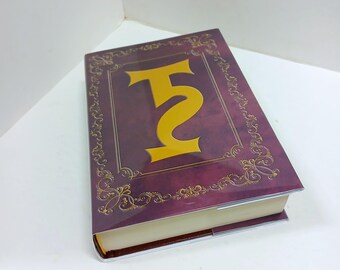 May include: A purple book with a gold border and the number "52" on the cover.