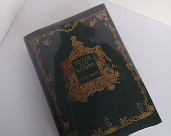 May include: A green book with a gold border and illustrations. The title is "Peter and Wendy" by J.M. Barrie.
