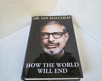 May include: A hardcover book titled "How the World Will End" by Dr. Ian Malcolm. The book cover features a portrait of a man wearing glasses. The title is in white, bold font against a black background.