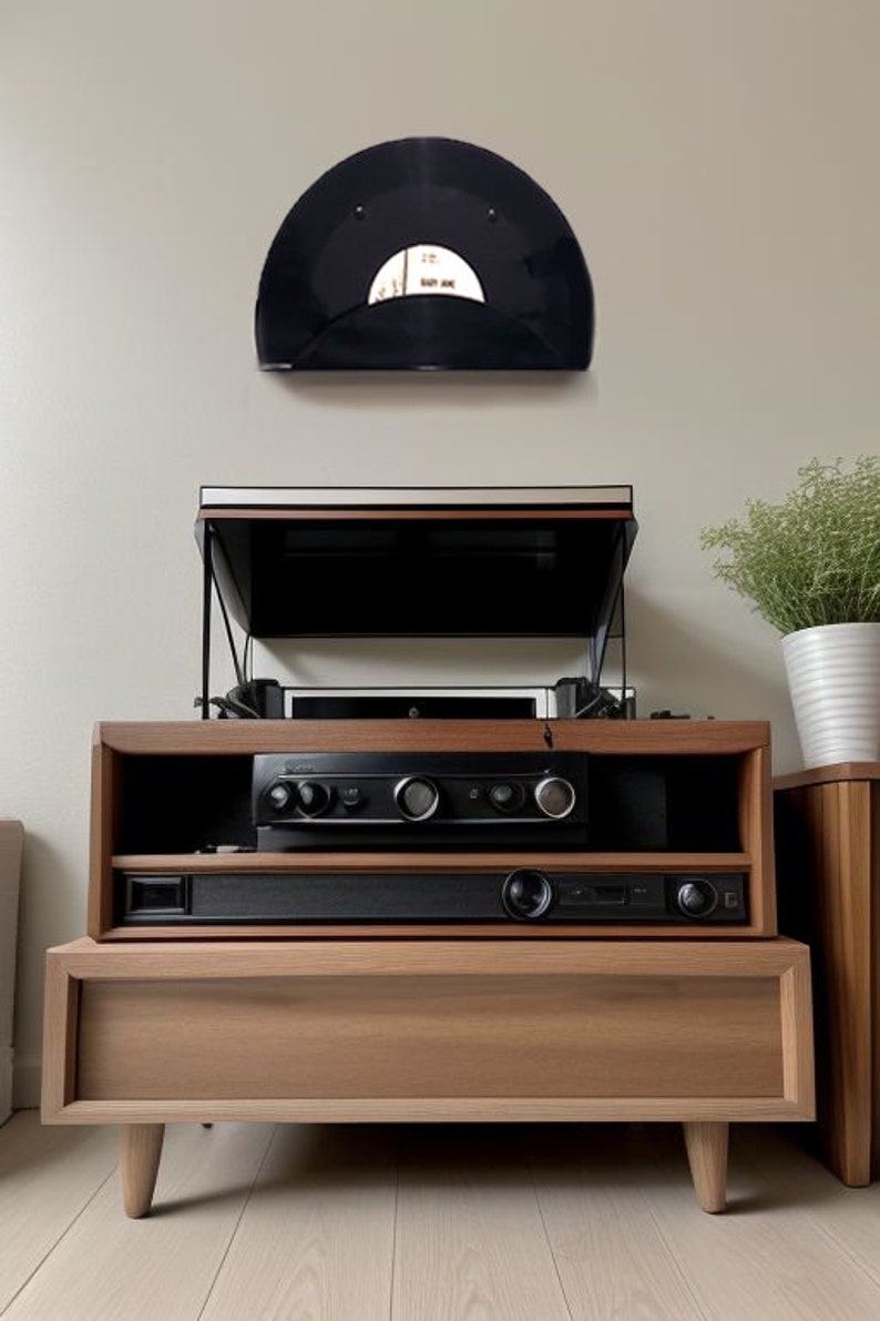 May include: A wooden media console with a record player, audio components, and a mounted vinyl record. The console has a light brown finish and a minimalist design. A small potted plant sits on a side table.