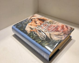 May include: A hardcover book titled "Misery's Return" by Paul Sheldon. The cover features a romantic illustration of two figures in a forest setting. The spine displays the title "Misery's Return" and the author's name.