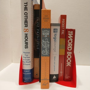 Straight on view of the red vinyl records, bent on the bottom to make bookends that holds up some bright, colorful books.