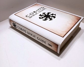 May include: A white book with a brown spine and a black and white illustration of a symbol on the cover. The title of the book is "Cobin's Spiric Guide".
