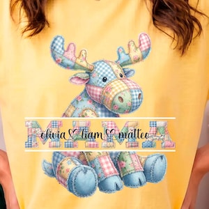 Puede incluir: Camiseta amarilla con un diseño de alce de retazos y los nombres Olivia, Liam y Matteo. El alce es en tonos azules, rosas y verdes. La camiseta es de estilo casual.