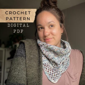 Op de afbeelding: Een vrouw draagt een gehaakte sjaal met een kantpatroon en een mix van kleuren. De afbeelding bevat de tekst "CROCHET PATTERN DIGITAL PDF". De vrouw draagt een groene en grijze trui.