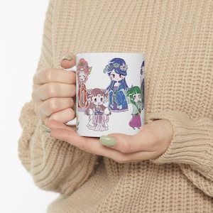 Könnte beinhalten: Weißer Keramikbecher mit einer farbenfrohen Illustration von mehreren Anime-Charakteren in traditioneller asiatischer Kleidung. Die Charaktere sind in verschiedenen Posen und Outfits dargestellt, mit Details wie floralen Haarschmuck und fließenden Gewändern.