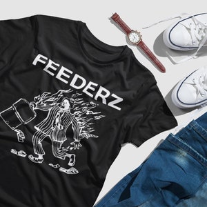 May include: Black t-shirt with a white graphic of a person on fire holding a briefcase. The text "FEEDERZ" is printed on the shirt.