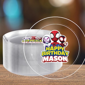 May include: A stack of clear plastic plates with a Spider-Man themed graphic. The graphic includes three Spider-Man characters and the text "HAPPY BIRTHDAY MASON" in yellow and blue.