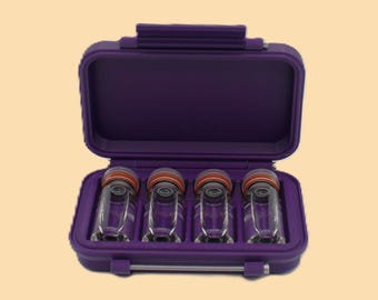May include: A purple carrying case with an open lid, revealing four clear glass vials with orange and black caps. The case is rectangular with rounded corners and a handle on top.