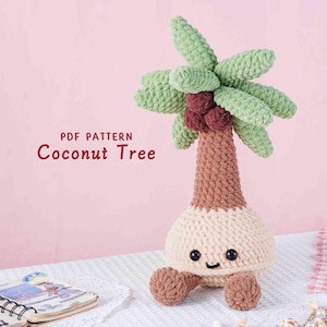 May include: A handmade crochet coconut tree with a smiling face, green leaves, and brown trunk. The tree has a light beige base and small brown feet. The text "PDF PATTERN Coconut Tree" is displayed on the image.