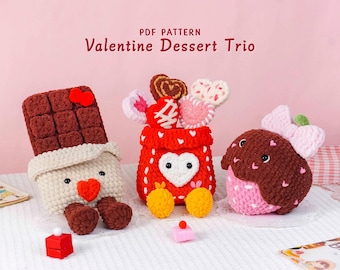 May include: A crochet Valentine's Day dessert trio. The set includes a chocolate bar, a red container with heart-shaped candies, and a strawberry. The text "PDF PATTERN Valentine Dessert Trio" is at the top.