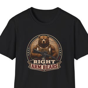 May include: A black short-sleeved t-shirt featuring a circular graphic of a brown bear wearing a tactical vest and holding a rifle. The text reads The Right To Arm Bears, set against a background resembling a historical document with stars.