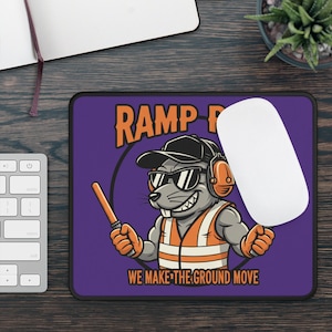 May include: A rectangular mousepad with a purple background featuring a cartoon rat wearing sunglasses, a hard hat, and an orange safety vest. The text "RAMP" and "WE MAKE THE GROUND MOVE" are displayed in orange and white.