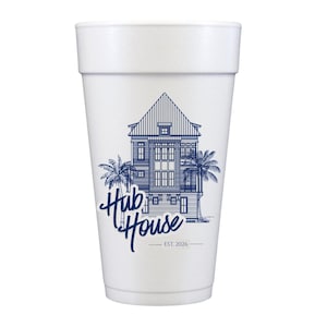 May include: A white foam cup featuring a blue illustration of a house with palm trees. The text "Hub House" is written in a cursive font, with "EST. 2026" below. The cup is designed for beverages.