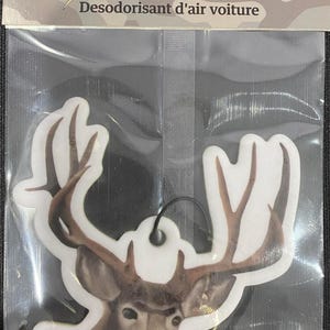 May include: A white car air freshener with a brown deer head and antlers. The text "SCENT RACKS" is printed on the packaging. The text "Car Air Freshener" and "Desodorisant d'air voiture" is printed on the packaging. The packaging is camo-patterned.