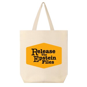 Peut inclure: Sac fourre-tout crème avec le texte "Release the Epstein Files" en lettres noires sur un hexagone jaune. Le sac a deux poignées crème.