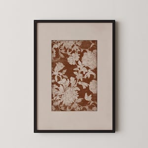 Peut inclure: Impression florale encadrée avec un motif détaillé de fleurs et de feuillage blancs sur un fond brun foncé. L'impression est encadrée dans un passe-partout crème et un cadre noir, créant une esthétique classique et élégante. Idéal pour la décoration intérieure.