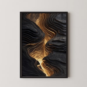 May include: Abstract art print in a black frame. The artwork features a layered, textured design with dark gray and gold tones, resembling a canyon or geological formation. The gold areas appear to glow.