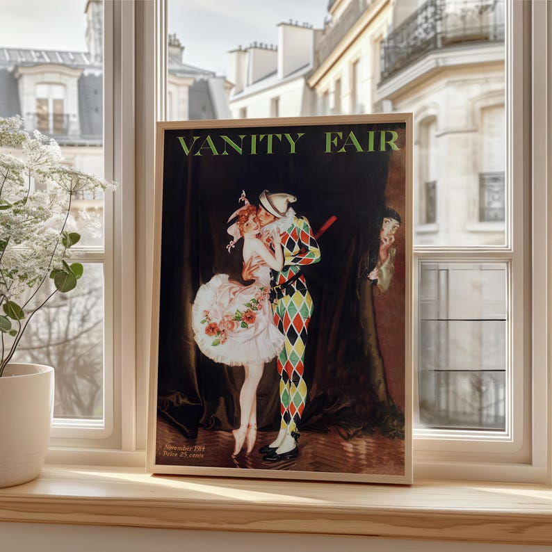 The Art Nouveau Vanity Fair print framed in ornate gold, hanging above a dark wood writing desk in a classic study.