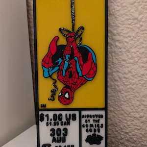 Puede incluir: Una placa de pared rectangular con fondo amarillo y la palabra MARVEL en letras negras. Un gráfico de Spider-Man cuelga boca abajo de una telaraña negra. La parte inferior incluye el texto: $1.00 US, $1.25 CAN, 303, AUG, 02457 y APPROVED BY THE COMICS CODE AUTHORITY.