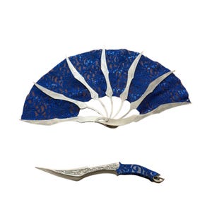 Può includere: Un ventaglio decorativo e un pugnale abbinato. Il ventaglio presenta un design in pizzo blu con dettagli argentati. Il pugnale ha una lama argentata con dettagli ornati e un'impugnatura rivestita in pizzo blu.