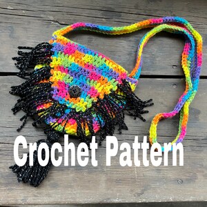 May include: A colorful crochet bag with a rainbow pattern, black fringe, and a strap. The bag features a button closure and the words "Crochet Pattern" in white text.