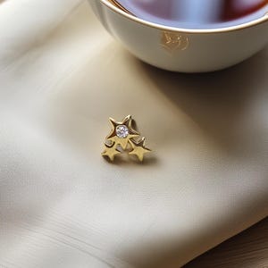 Brinco de estrela tripla em ouro maciço 14K com zircônia central – piercing elegante para tragus e cartilagem