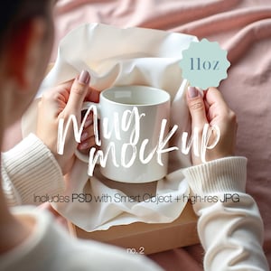 以下が含まれることがあります： 白いセラミック製のマグカップに11オンスのラベルが貼られており、人の手で持たれています。マグカップは白い布の背景に置かれ、白い文字で「マグモックアップ」と書かれています。