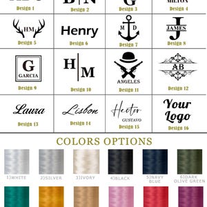 May include: A grid of sixteen black graphic design options featuring various monograms, names, and symbols, including mountains, anchors, and firearms. Below, a color palette displays twelve thread spools in white, silver, ivory, black, navy blue, dark olive green, teal, gold, bronze, light pink, tuscan red, and plum.