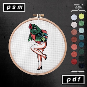 May include: Cross-stitch embroidery in a wooden hoop features a fish-headed figure with a backpack and high heels. The design uses red, green, and beige thread. The text "psm" and "pdf" are in the corners.