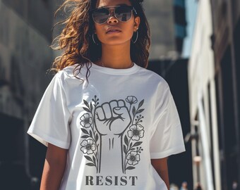 May include: White t-shirt with a black graphic of a raised fist surrounded by flowers and the word "RESIST" underneath.